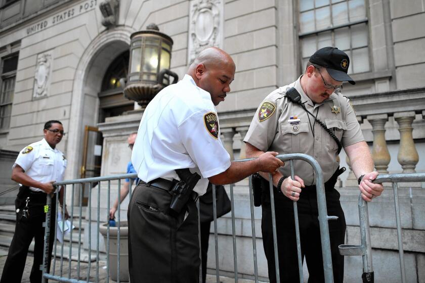 Baltimore sheriff's deputies place barricades in front of the courthouse before pre-trial hearings for six police officers charged in the death of Freddie Gray.