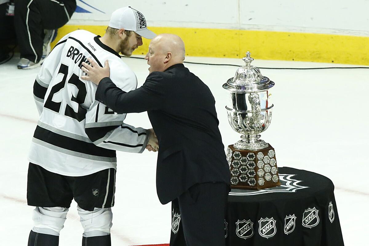 Kings captain Dustin Brown is congratulated by NHL Deputy Commissioner Bill Daly after the Kings won the Clarence S. Campbell bowl for the Western Conference's top team following their win over the Chicago Blackhawks in Game 7 of the Western Conference finals.