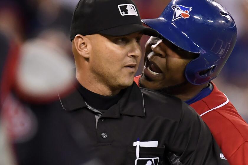 Blue Jays designated hitter Edwin Encarnacion exchanges words with umpire Vic Carapazza, left, before Encarnacion was ejected from the game over a strikeout debate.