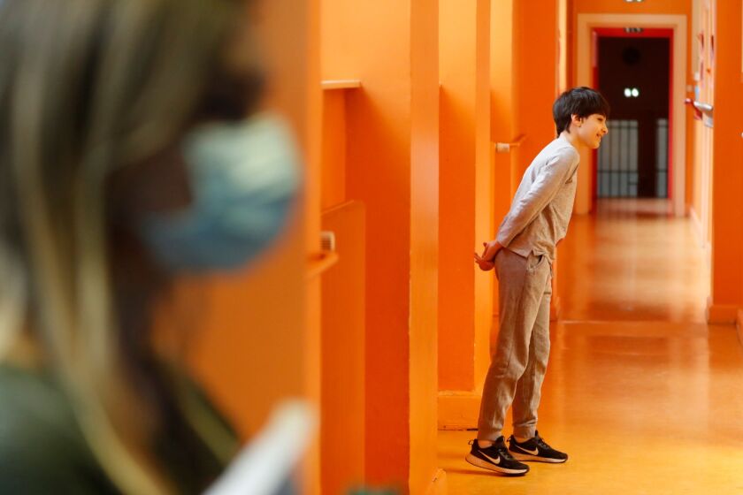 A boy waits outside a classroom in a corridor of a school in Strasbourg, eastern France, Thursday, May 14, 2020. The government has allowed parents to keep children at home amid fears prompted by the COVID-19, as France is one of the hardest-hit countries in the world. Authorities say 86% of preschools and primary schools are reopening this week. (AP Photo/Jean-Francois Badias)
