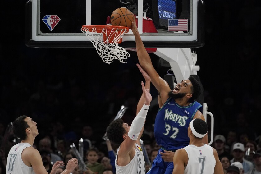 Minnesota Timberwolves center Karl-Anthony Towns (32) dunks over Oklahoma City Thunder forward Isaiah Roby, center, in the second half of an NBA basketball game Friday, March 4, 2022, in Oklahoma City. (AP Photo/Sue Ogrocki)
