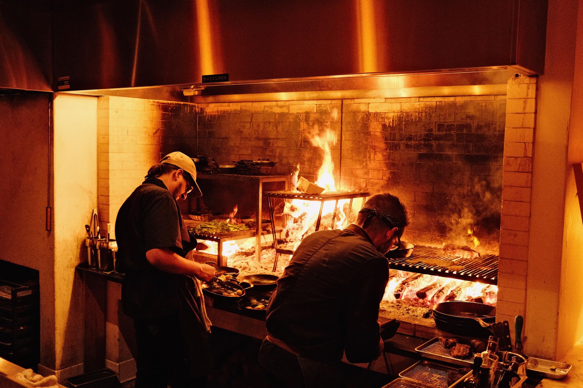 Two men are cooking at the alphabety fingers in the heart of wood.