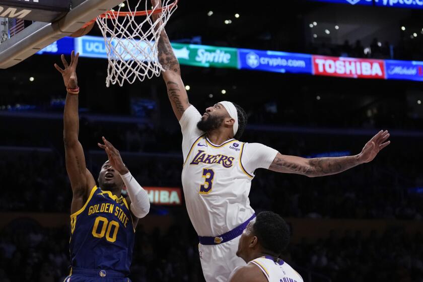 Golden State Warriors forward Jonathan Kuminga (00) shoots against Los Angeles Lakers forward.