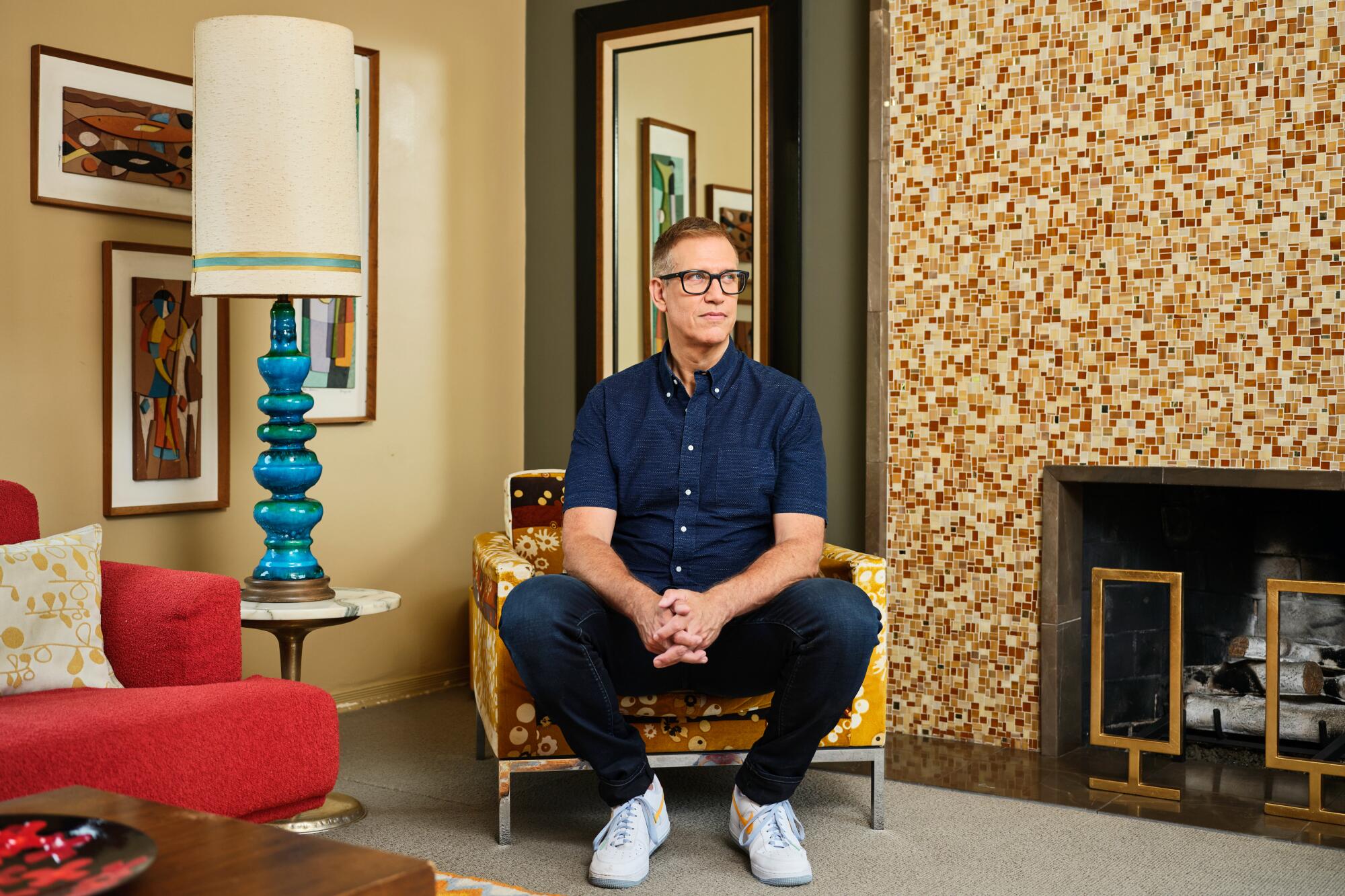 A man is sitting in a colorful living room.