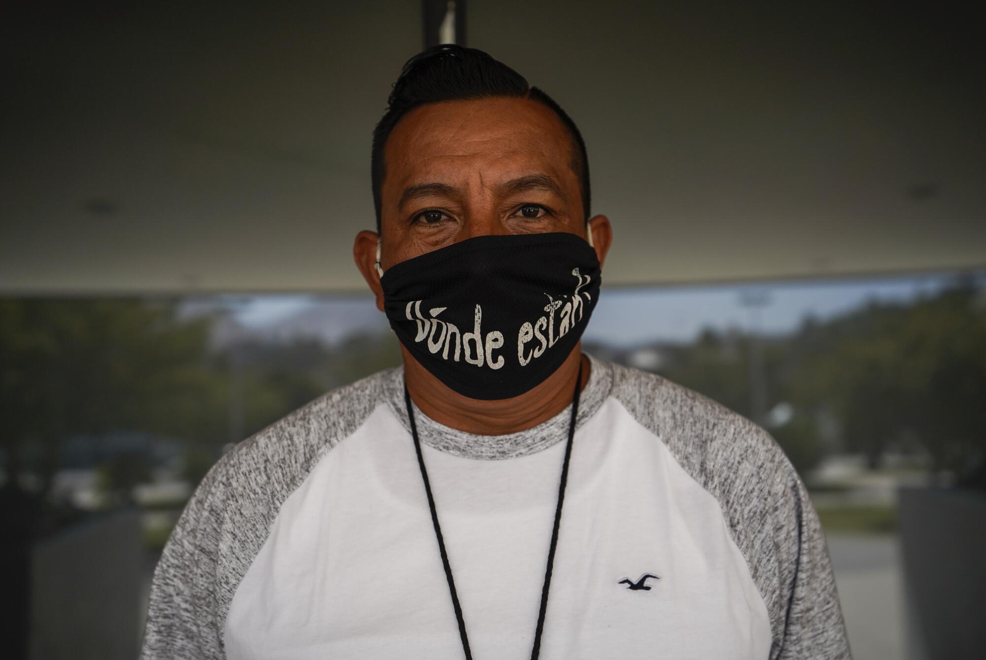 Eddy Carrillo is searching for his missing son, Erick. His mask reads "Where are they?"