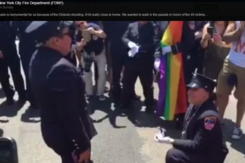 Fire Department New York EMTs Julianna Arroyo gets down on one knee to propose to Erika Marrero at Sunday's NYC Pride March.