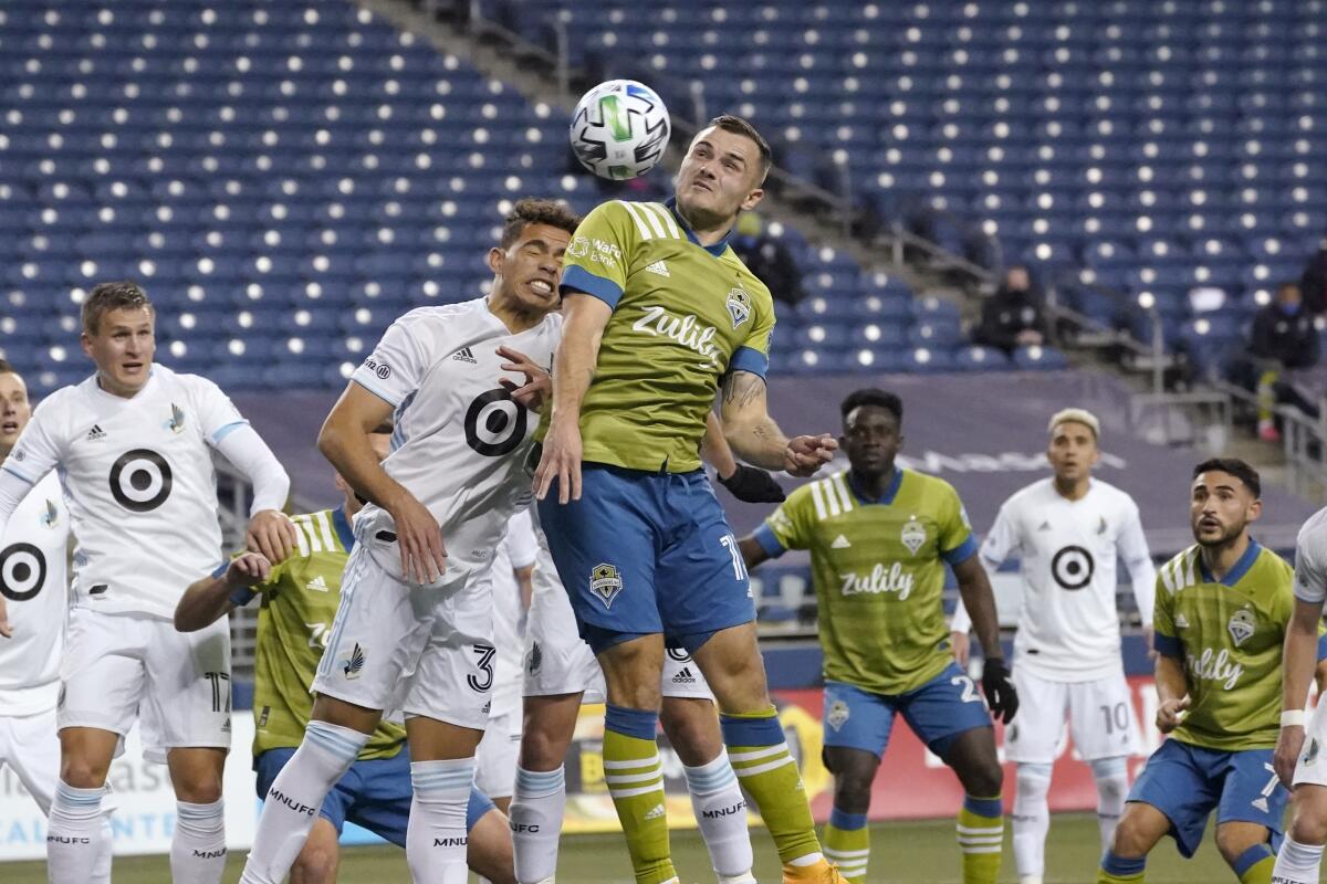 Minnesota United midfielder Hassani Dotson, front left, and Seattle Sounders forward Jordan Morris leap to head the ball