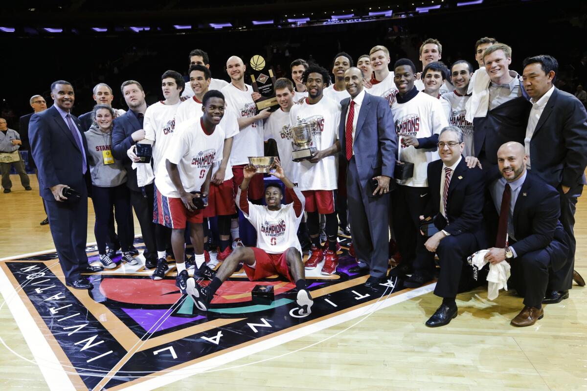 The Stanford Cardinal pose for a photo after winning the NIT tournament in overtime against Miami, 66-64.