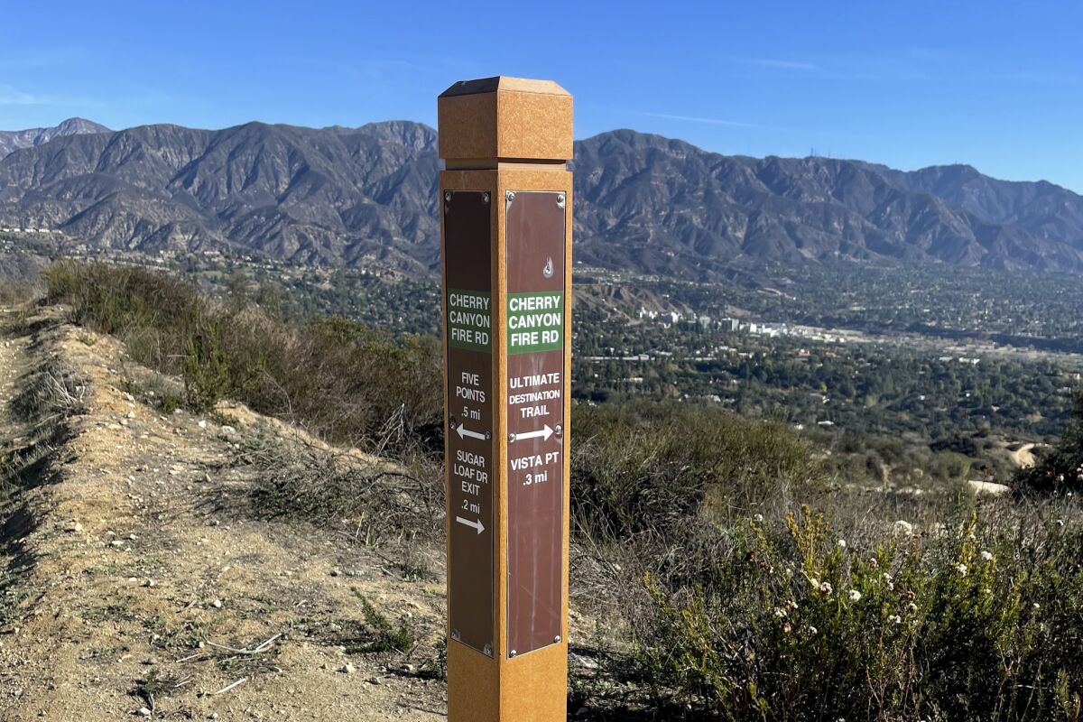 A sign on a hiking trail that says "Cherry Canyon Fire Rd"