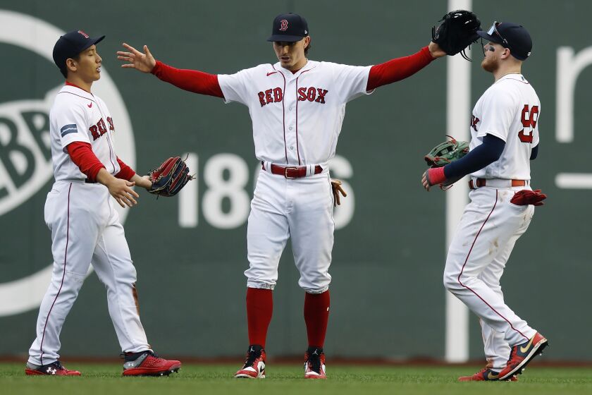 Boston Red Sox outfielders, from left to right, Masataka Yoshida, Jarren Duran and Alex Verdugo celebrate after defeating the Tampa Bay Rays in the first game of a baseball doubleheader, Saturday, June 3, 2023, in Boston. (AP Photo/Michael Dwyer)