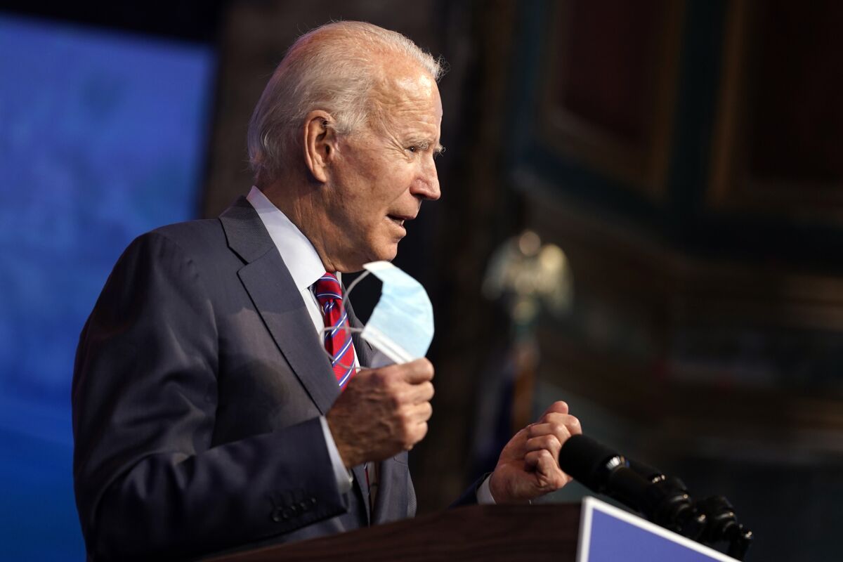 President-elect Joe Biden holds up a mask as he speaks about the COVID-19 pandemic.