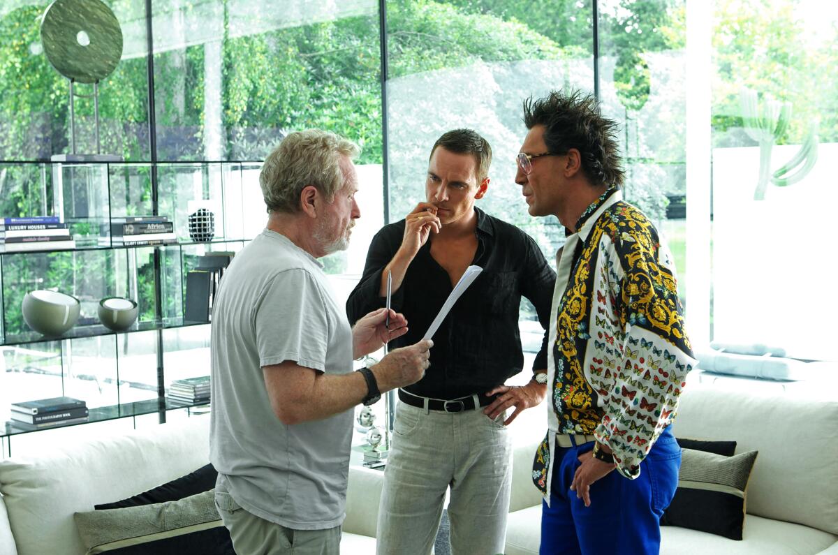Three men discuss a scene on a movie set.