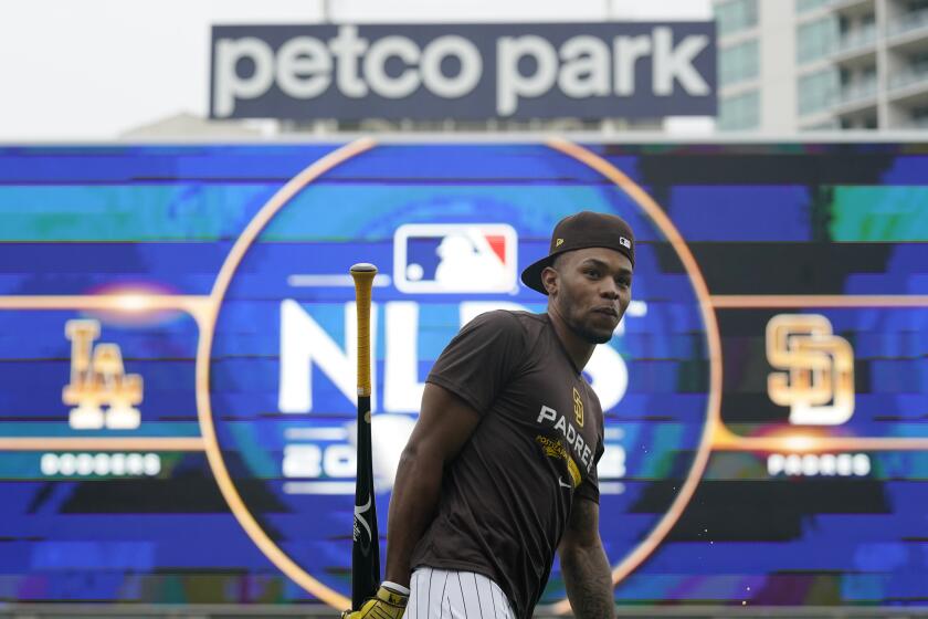 San Diego Padres right fielder Jose Azocar walks in front of the Petco Park sign and scoreboard during a workout