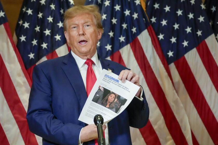 FILE - Former President Donald Trump holds up a copy of a story featuring New York Attorney General Letitia James while speaking during a news conference, Jan. 11, 2024, in New York. Trump could find out Monday, March 25, how New York state aims to collect over $457 million he owes in his civil business fraud case, even as he appeals the verdict that led to the gargantuan debt. (AP Photo/Mary Altaffer, File)