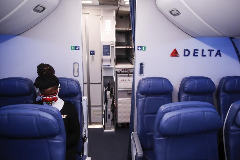 FILE - In this May 28, 2020, file photo, Delta Airlines employee wears personal protective equipment after landing at Minneapolis?Saint Paul International Airport, in Minneapolis. Airlines are trying to convince a frightened public that measures like mandatory face masks and hospital-grade air filters make sitting in a plane safer than many other indoor settings during the coronavirus pandemic, but it isn’t working. (AP Photo/John Minchillo, File)