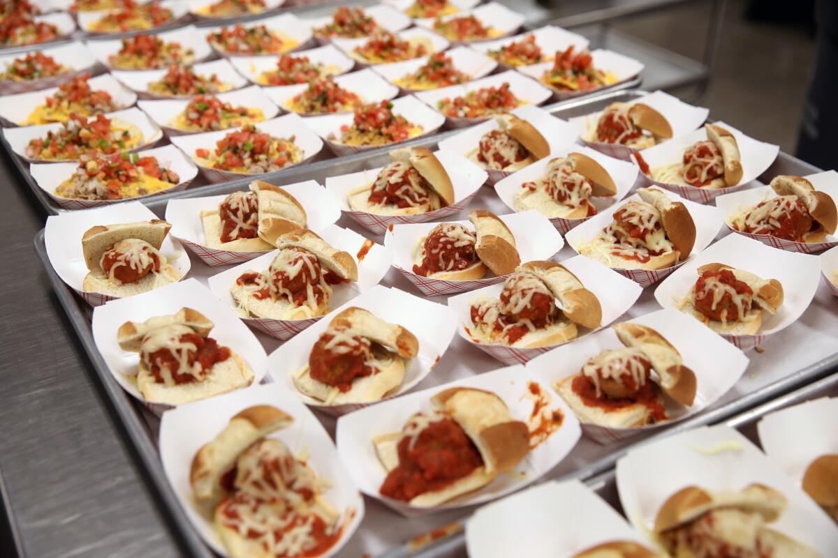 Tacos and meatball sub sandwiches on a tray 