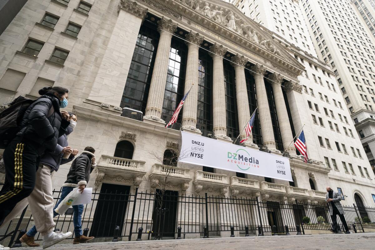 Pedestrians pass the New York Stock Exchange.