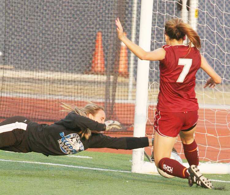 Burbank keeper Katie Hooper dives and reaches desperately to stop the point-blank on-goal shot by Simi Valley's Marissa Hueckea in overtime of the first-round CIF playoff soccer game played at Burbank High School in Burbank on Tuesday, February 12, 2011. Burbank won the game in overtime with a game winning goal.