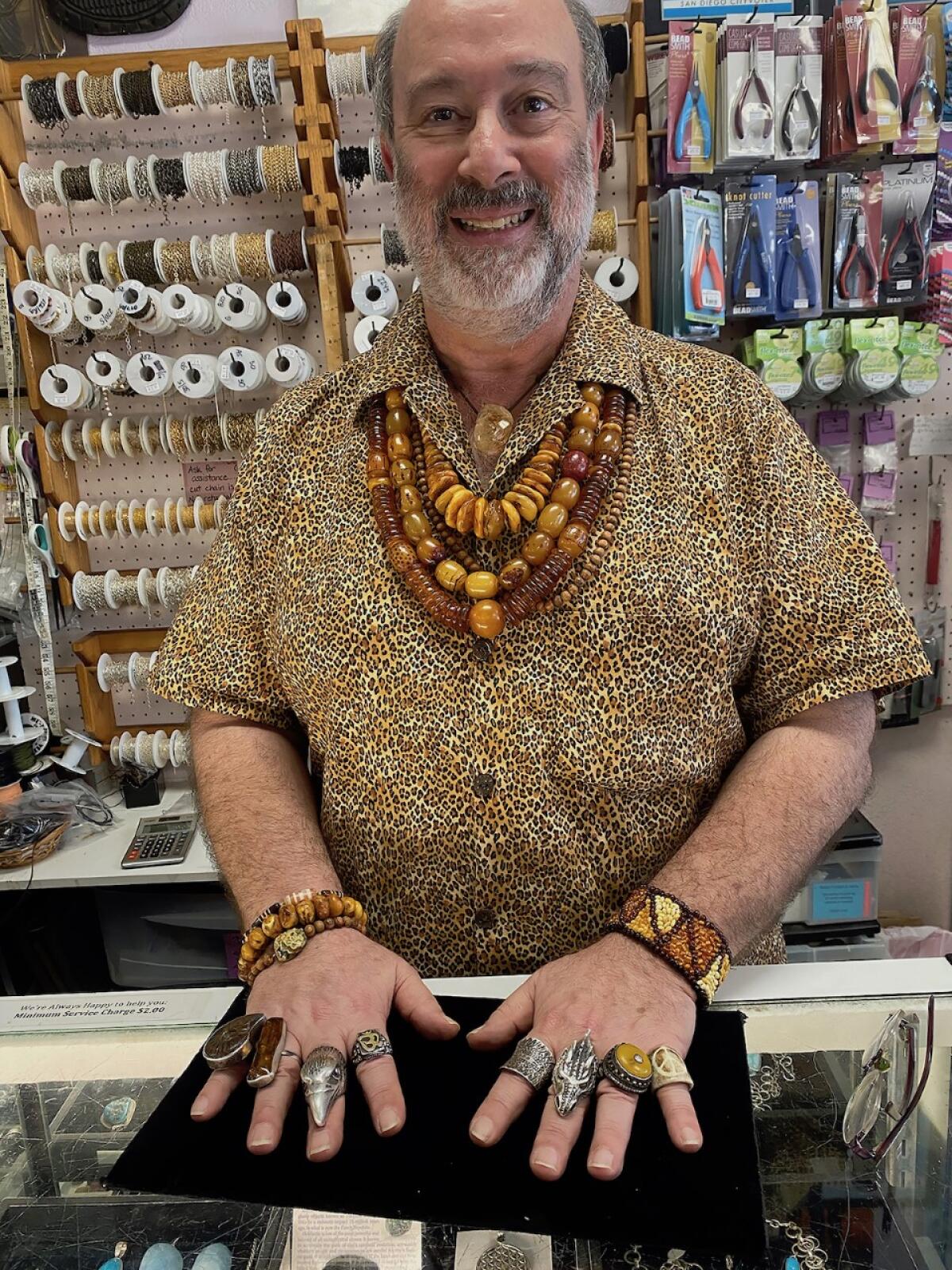 Phil Fischman, behind the counter at Beads, Crystals and More, wearing some of his favorite pieces.