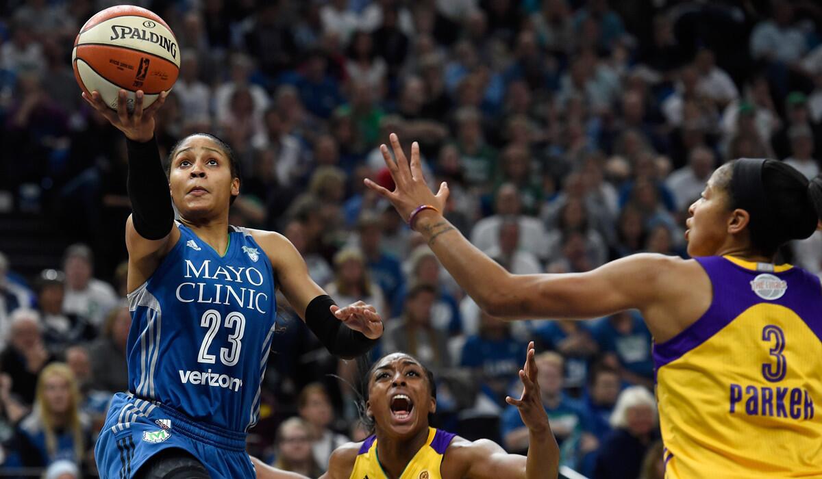 Minnesota Lynx's Maya Moore, left, shoots a basket against Sparks' Nneka Ogwumike, center, and Candace Parker during the second quarter in Game 2 of the 2016 WNBA Finals on Tuesday.