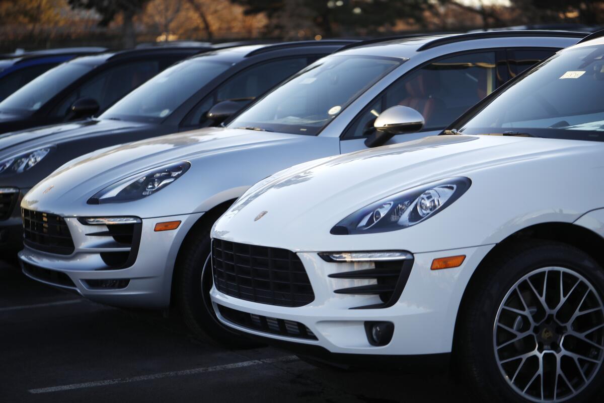 A row of unsold 2019 Porsche Macan sport utility vehicles on a lot. 