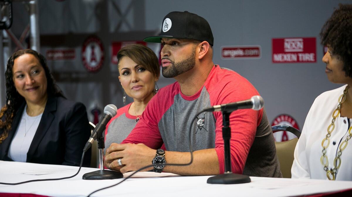 Deidre Pujols watches as her husband, Albert, speaks during a news conference about "Strike Out Slavery" at Angel Stadium on Aug. 24.