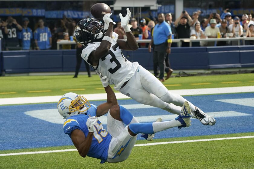 Jacksonville Jaguars cornerback Tre Herndon (37) breaks up a pass intended for Los Angeles Chargers wide receiver Jalen Guyton (15) during the second half of an NFL football game in Inglewood, Calif., Sunday, Sept. 25, 2022. (AP Photo/Marcio Jose Sanchez)