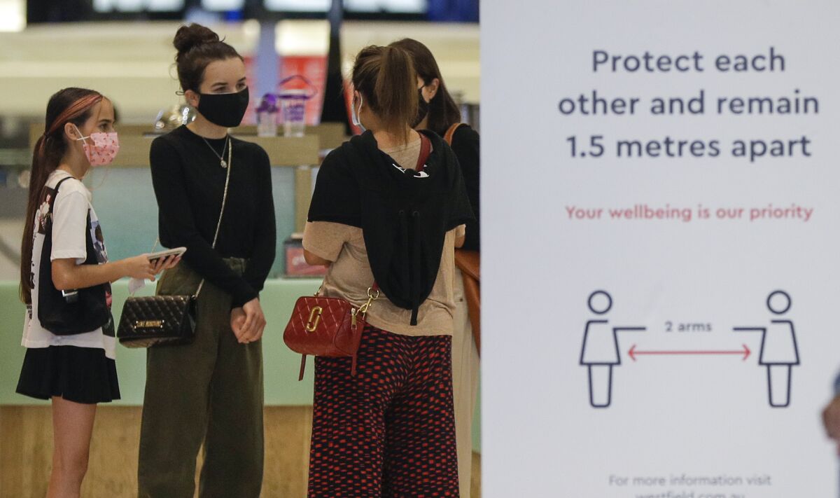 Shoppers wear masks as they walk around a shopping precinct in Sydney, Australia, Sunday, Jan. 3, 2021. Masks have been made mandatory in shopping centers, on public transport, in entertainment venues such as a cinema, and fines will come into effect on Monday as the state government responds to the COVID-19 outbreak on Sydney's northern beaches, which is suspected to have also caused new cases in neighboring Victoria state. (AP Photo/Mark Baker)