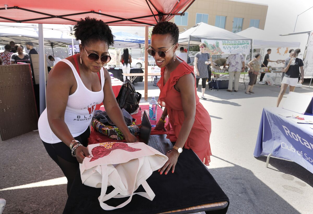 Dree Berry, left, admires the butterfly on the canvas bag of Jasmine L. Sadler, right. Berry is with San Diego Black Professionals and Sadler is with Jas:Maven and The STEAM Collaborative. Both attended the Summer Y.E.S. Fest held by Young Black&'N Business.