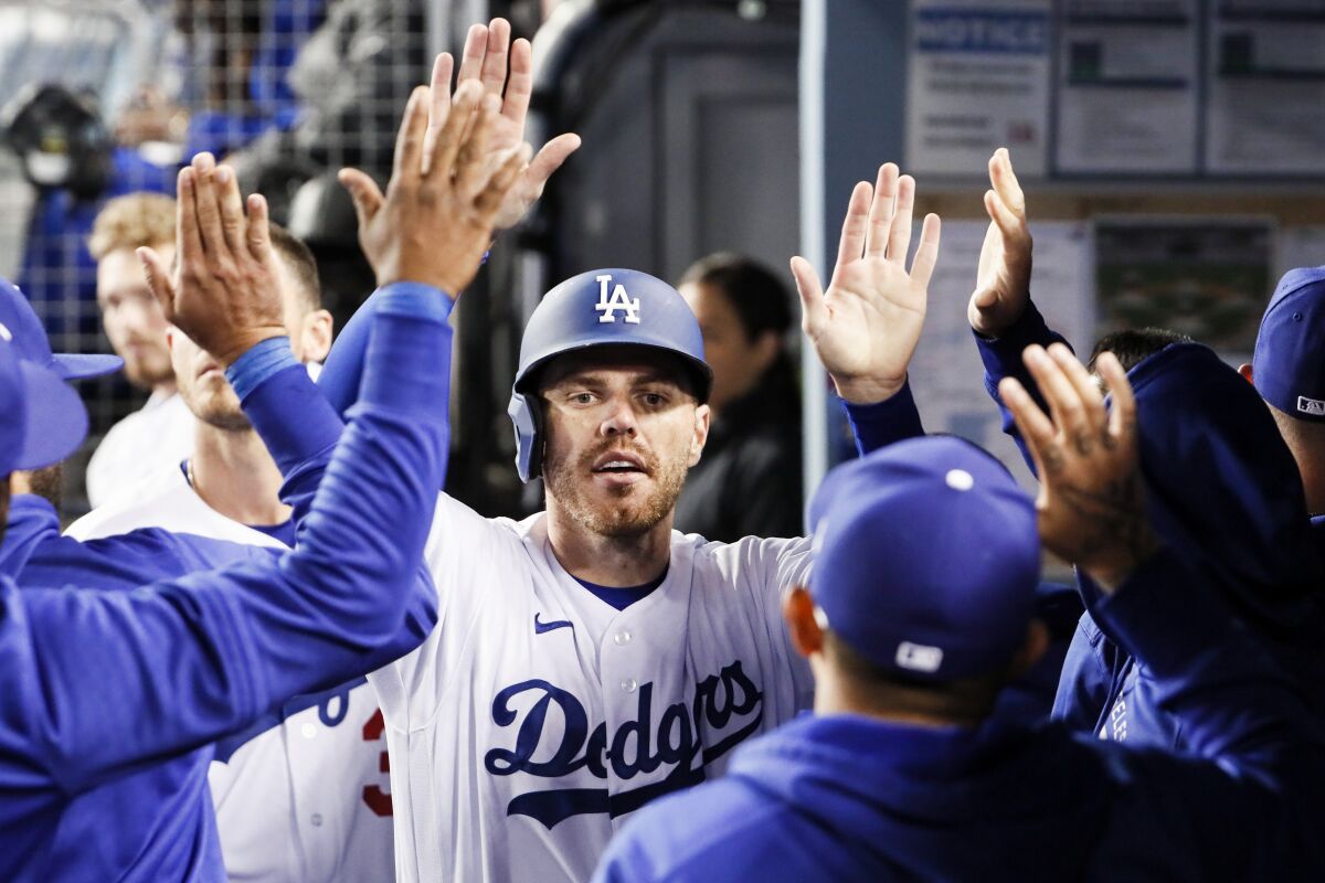 Dodgers first baseman Freddie Freeman celebrates with teammates in the dugout after scoring the go-ahead run.