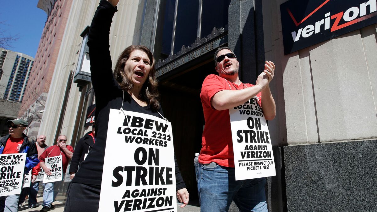 Verizon workers picket outside one of the company's facilities in Boston on April 13.