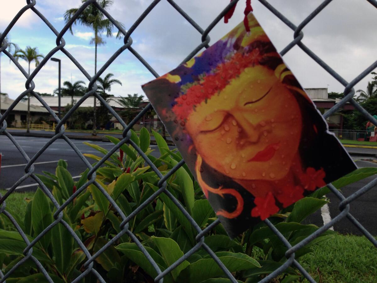 A prayer card depicting the volcano goddess Pele hangs from the fence surrounding Keonepoko Elementary School in Pahoa, Hawaii, which has been closed because of the eruption of Kilauea. However it was open as a polling place on Tuesday.