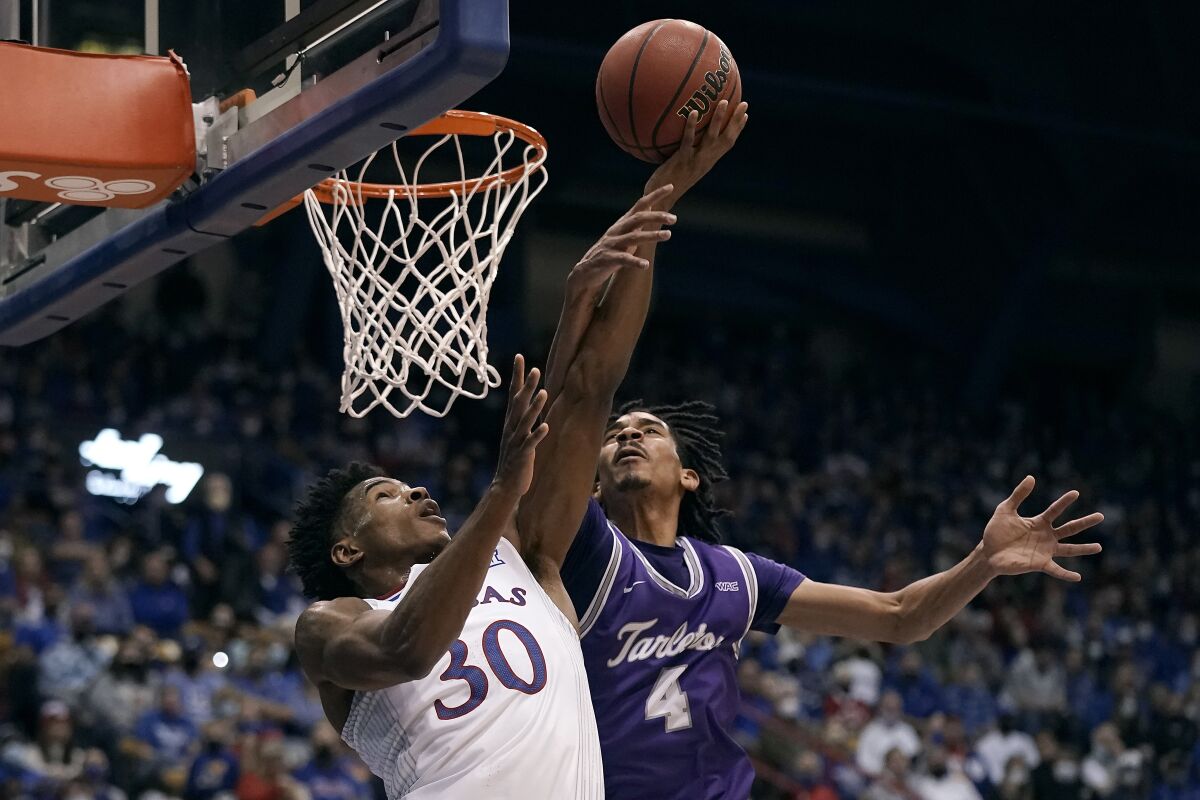 Kansas' Ochai Agbaji (30) shoots under pressure from Tarleton State's Tahj Small (4) during the first half of an NCAA college basketball game Friday, Nov. 12, 2021, in Lawrence, Kan. (AP Photo/Charlie Riedel)