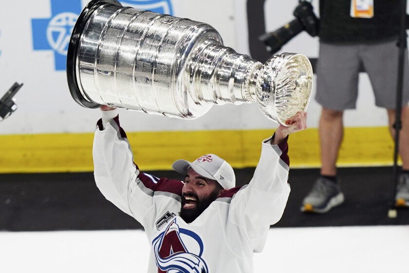 Colorado Avalanche center Nathan MacKinnon lifts the Stanley Cup after the team defeated the Tampa Bay Lightning 2-1 in Game 6 of the NHL hockey Stanley Cup Finals on Sunday, June 26, 2022, in Tampa, Fla. (AP Photo/John Bazemore)