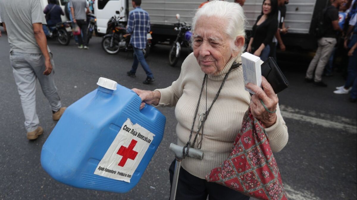 A woman receives humanitarian aid from the Red Cross in Caracas, Venezuela, on Tuesday.