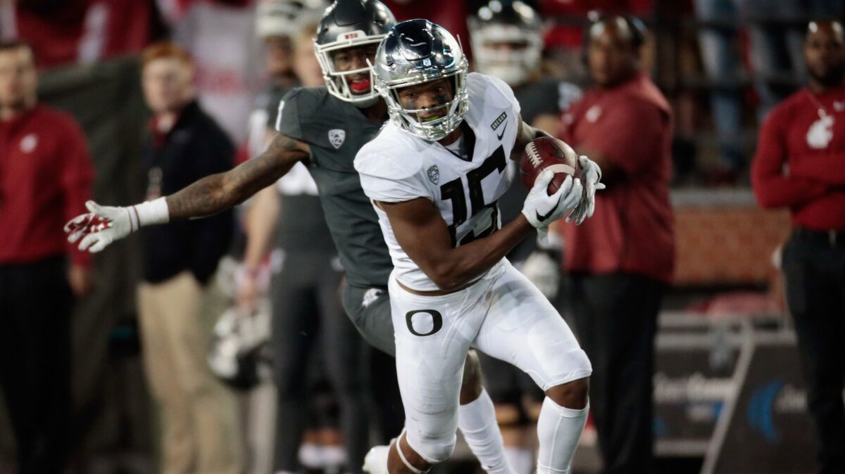 Oregon's Deommodore Lenoir (15) carries the ball against Washington State in the second half on Saturday.
