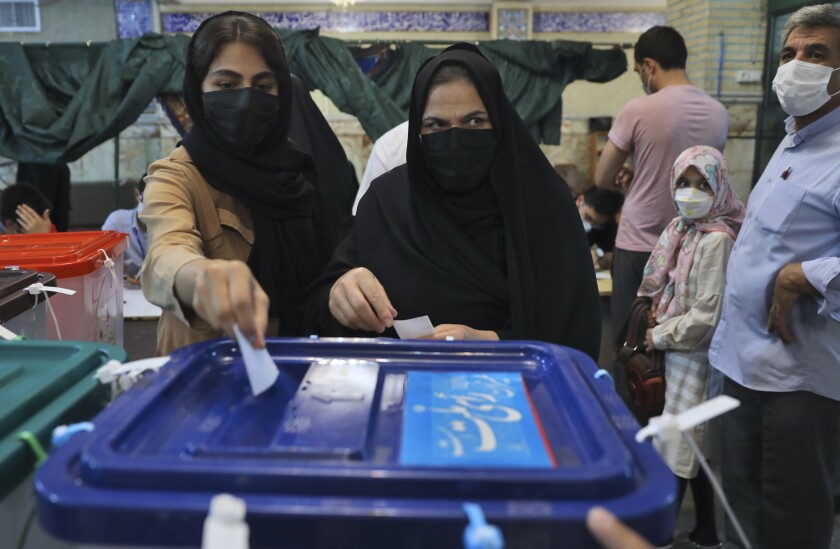 Voters cast their ballots for the presidential elections at a polling station in Tehran, Iran, Friday, June 18, 2021. Iranians voted Friday in a presidential election dominated by a hard-line protege of Supreme Leader Ayatollah Ali Khamenei after authorities disqualified nearly all of his strongest competition, leading to what appeared to be a low turnout fueled by apathy and calls for a boycott. (AP Photo/Vahid Salemi)