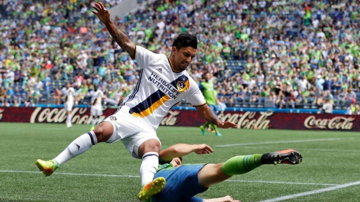 Galaxy defender A.J. DeLaGarza goes down on a tackle by Sounders midfielder Jordan Morris during the first half of a game in Seattle on July 31.