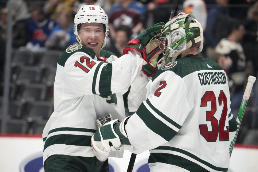 Minnesota Wild left wing Matt Boldy, left, congratulates goaltender Filip Gustavsson after the third period of an NHL hockey game against the Colorado Avalanche Wednesday, March 29, 2023, in Denver. (AP Photo/David Zalubowski)