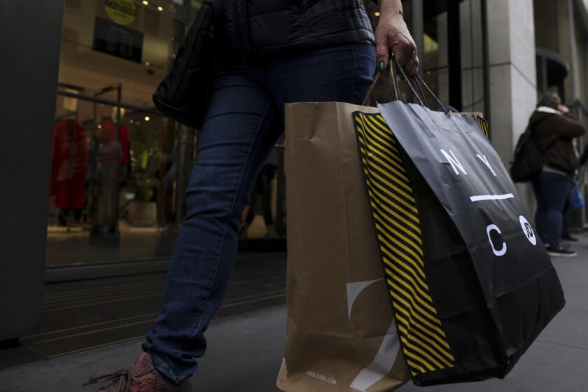 FILE - A shopper carries bags down Fifth Avenue on Black Friday, Nov. 25, 2022, in New York. Holiday sales rose as shoppers showed some resilience during the most important shopping season despite surging prices on everything from food to rent. (AP Photo/Julia Nikhinson, File )