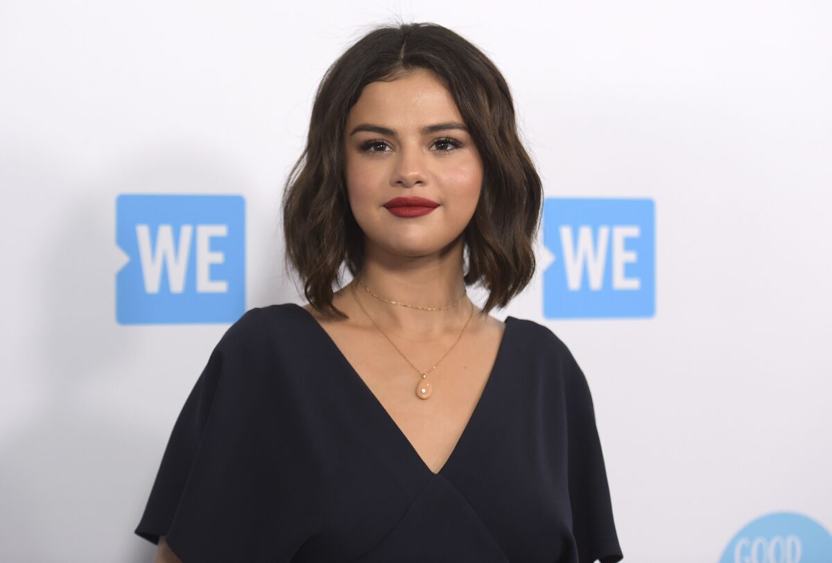 FILE - Selena Gomez arrives at WE Day California on April 19, 2018, in Inglewood, Calif. Gomez is taking the heat in the kitchen. The singer-actress slices and dices in “Selena + Chef,” debuting Aug. 13 on the new HBO Max streaming service. The 10-episode series was shot in the kitchen of Gomez’s new Los Angeles-area house. Her grandparents and two friends, who have been quarantining with her, serve as taste testers. (Photo by Richard Shotwell/Invision/AP, File)