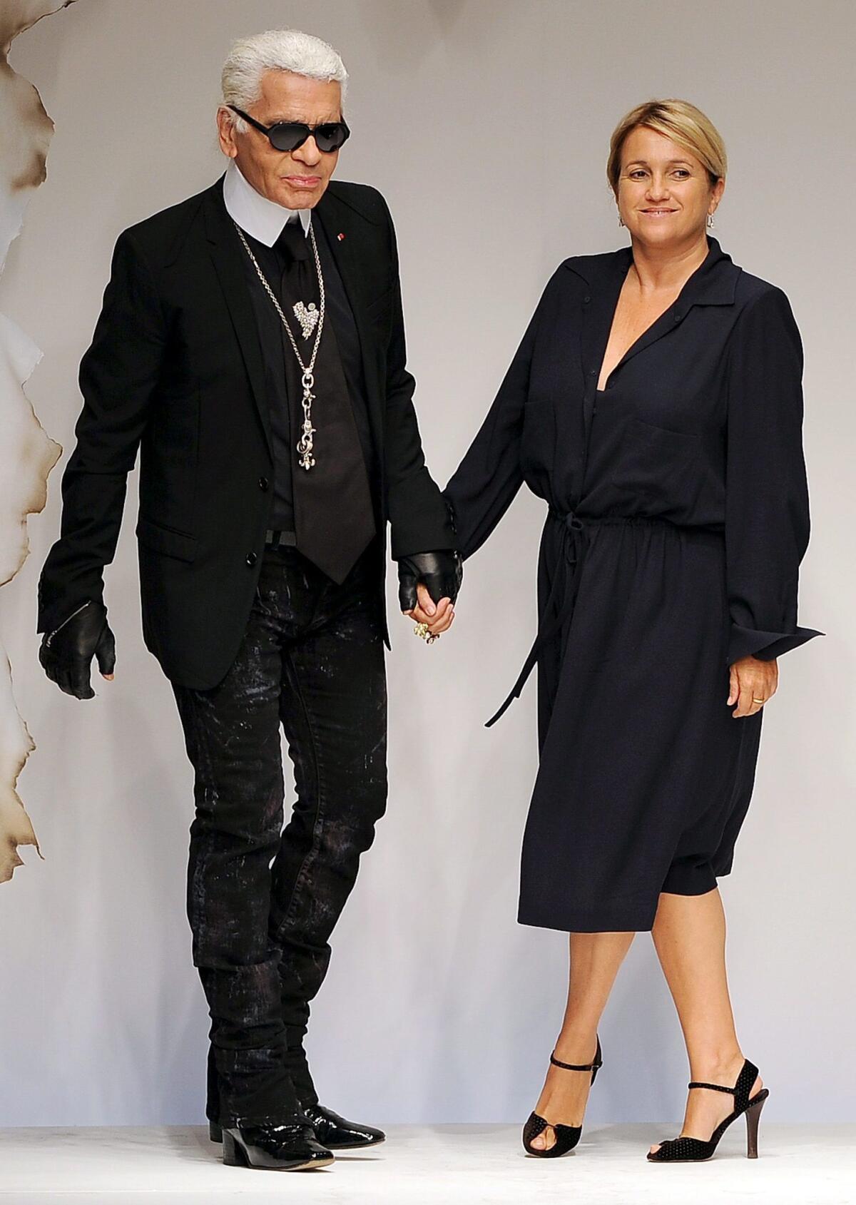 El diseñador Karl Lagerfeld y la diseñadora Silvia Venturini Fendi caminan por la pasarela al término de la presentación de la colección de Fendi durante la Semana de la Moda de Milán.