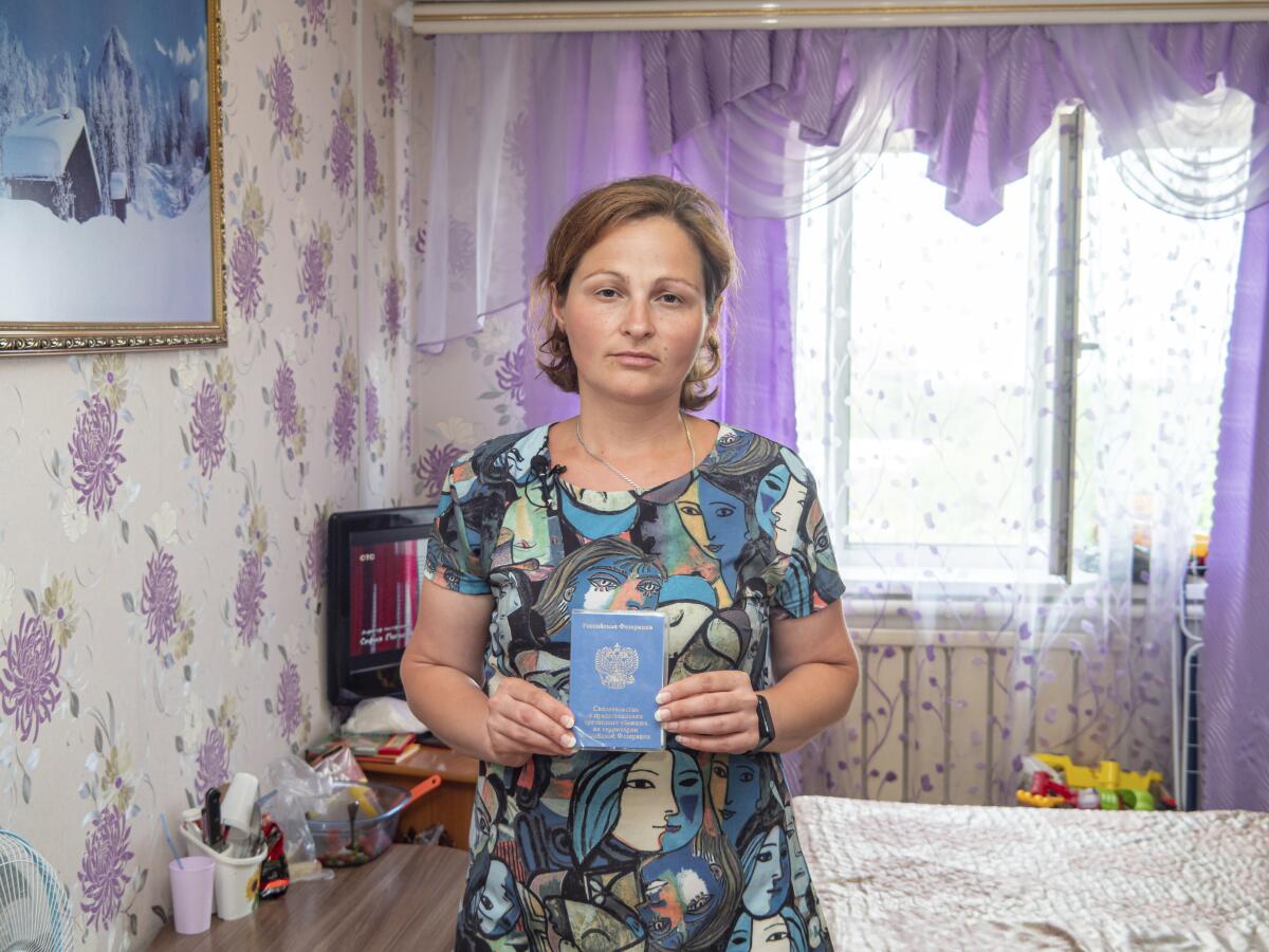An evacuee from Mariupol holds her Russian documentation.