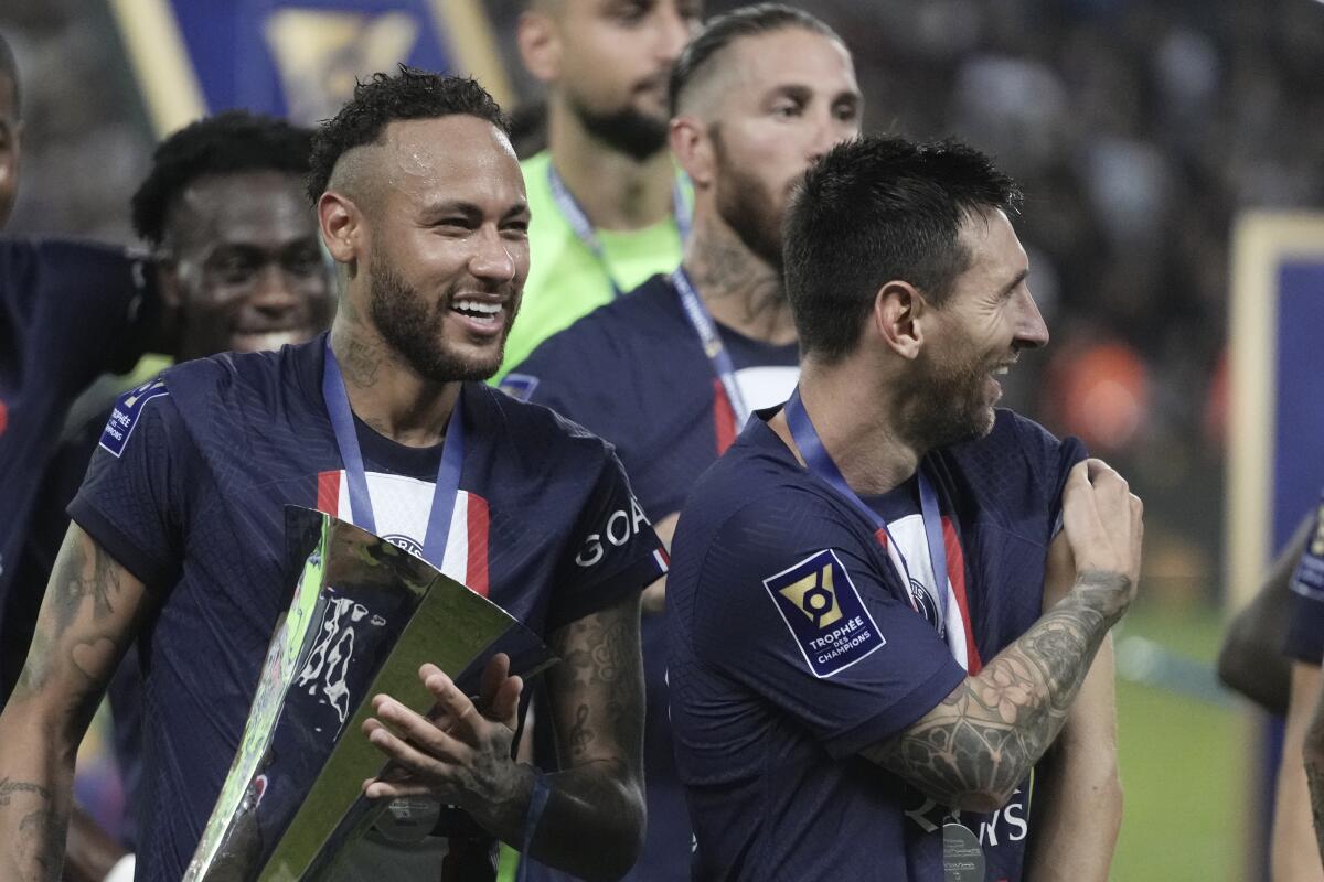 PSG's Neymar, left, holds the trophy as he celebrate with his teammate Lionel Messi after winning the French Super Cup final soccer match between Nantes and Paris Saint-Germain at Bloomfield Stadium in Tel Aviv, Israel, Sunday, July 31, 2022. PSG won 4-0. (AP Photo/Ariel Schalit)