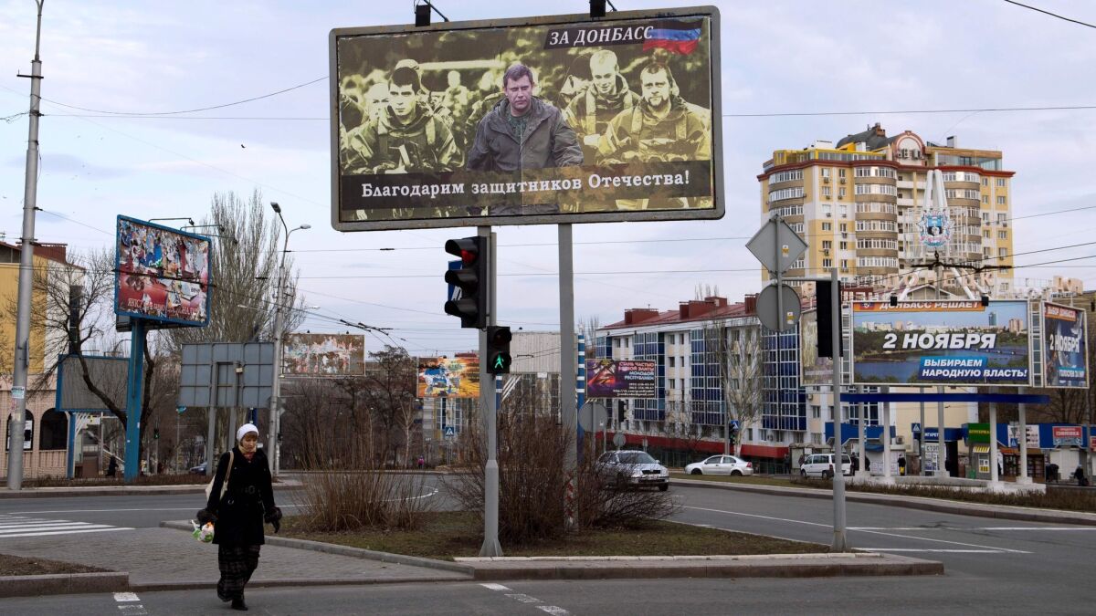 A woman walks under a billboard in Donetsk, Ukraine, in 2015 featuring a picture of the leader of the self-proclaimed Donetsk People's Republic, Alexander Zakharchenko.