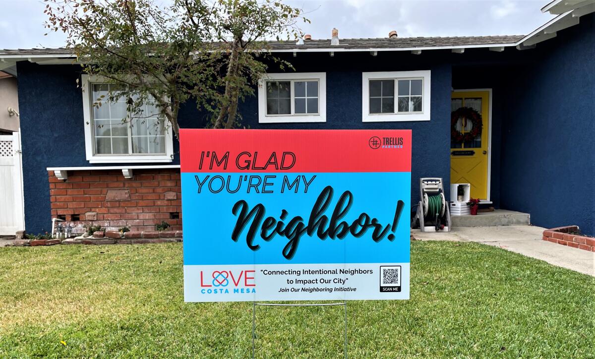 A yard sign advertises a new "I'm Glad You're My Neighbor" campaign in Costa Mesa spearheaded by the nonprofit Trellis.