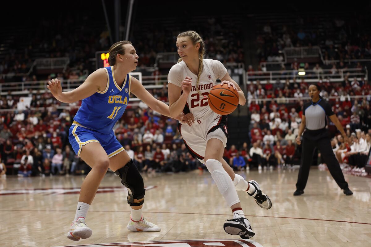 Stanford forward Cameron Brink, right, drives to the basket against UCLA forward Emily Bessoir.
