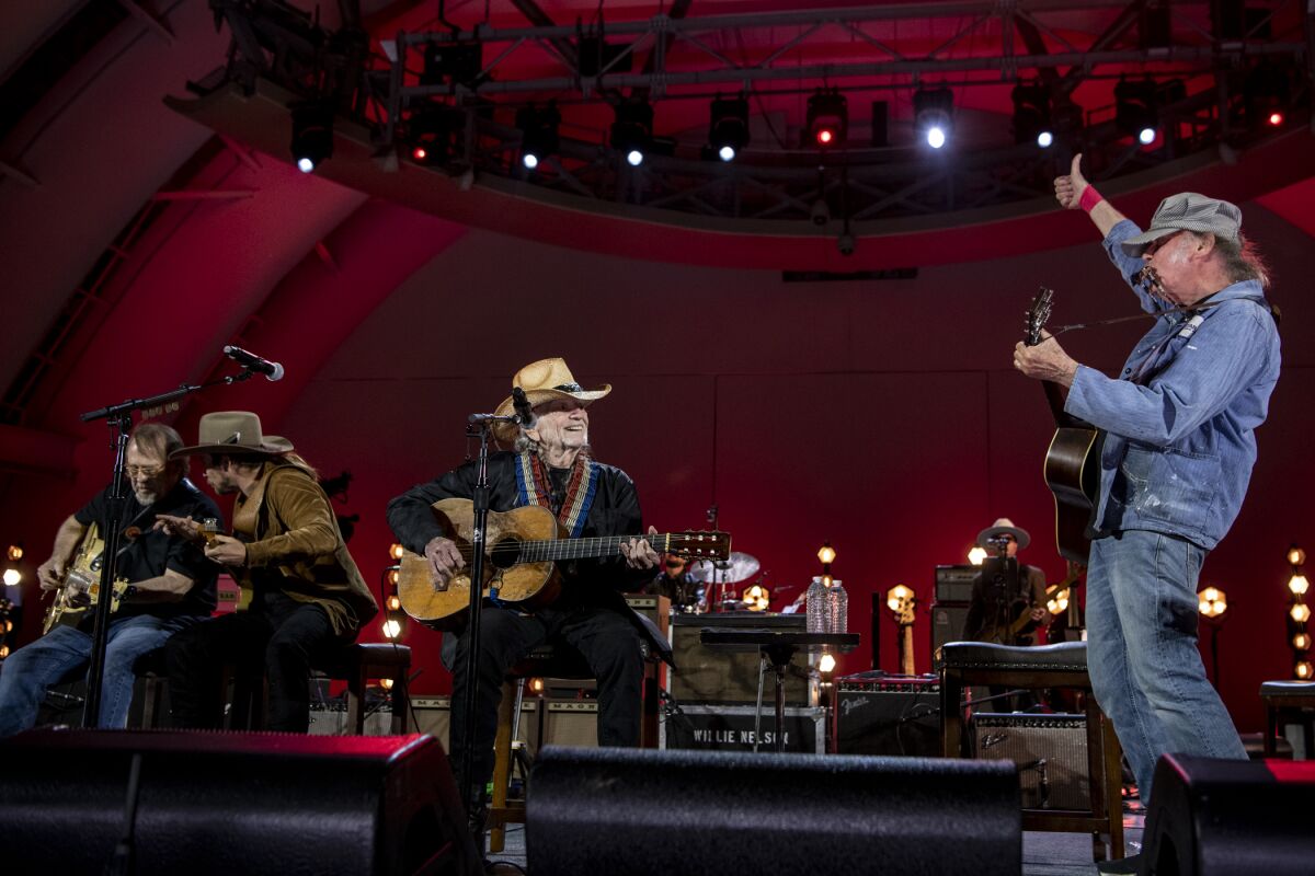 Wille Nelson performs with Neil Young onstage