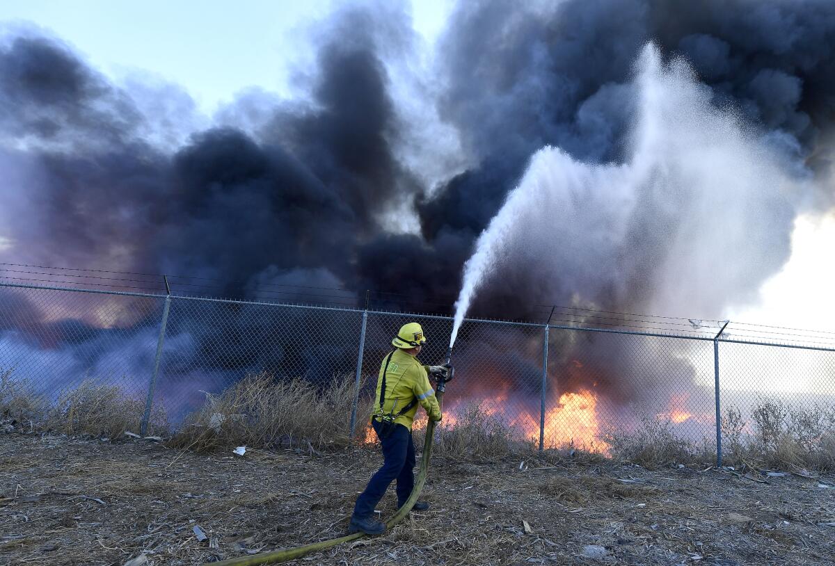 Un bombero combate un incendio fuera de control en Riverside, California