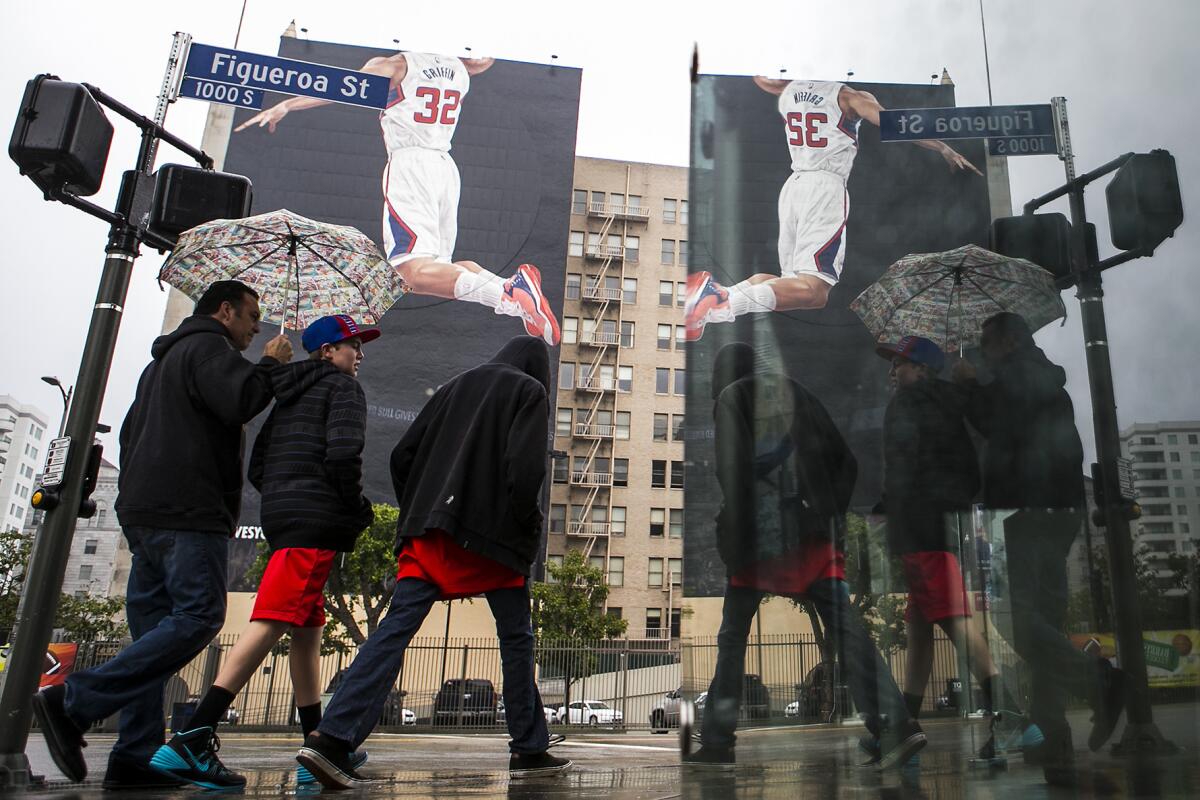 A mural featuring a headless Blake Griffin towers over the rain-soaked corner of Figuroa Street and W. Olympic Boulevard on Jan. 11.